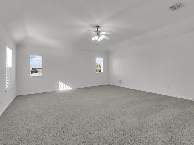 spare room with carpet, ceiling fan, plenty of natural light, and vaulted ceiling