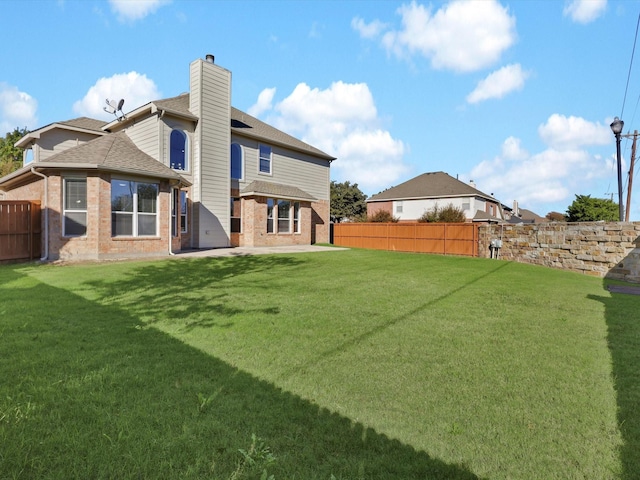 back of house featuring a yard and a patio