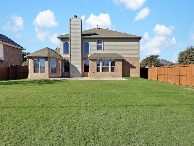 back of property with a patio area and a yard