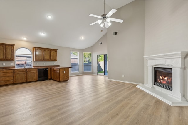 kitchen featuring ceiling fan, sink, high vaulted ceiling, dishwasher, and light hardwood / wood-style floors