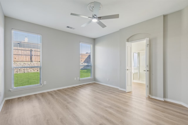 empty room with ceiling fan and light hardwood / wood-style flooring