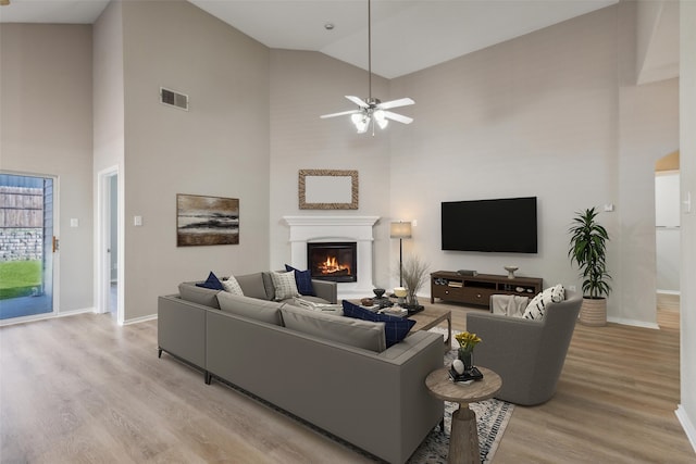 unfurnished living room featuring light wood-type flooring, high vaulted ceiling, and ceiling fan