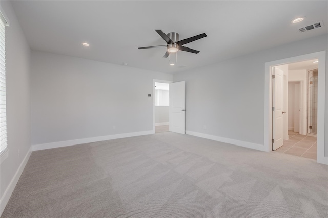 spare room with ceiling fan and light carpet