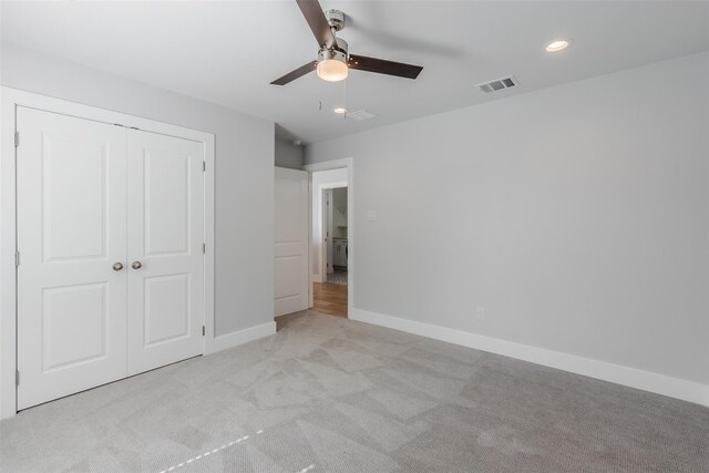 unfurnished bedroom with ceiling fan, a closet, and light colored carpet