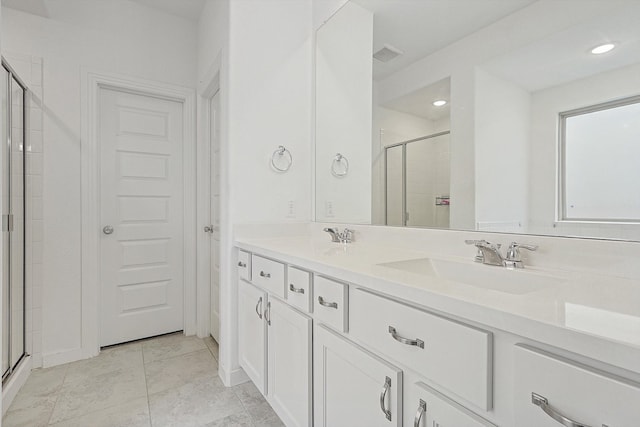 bathroom featuring tile patterned flooring, vanity, and a shower with shower door