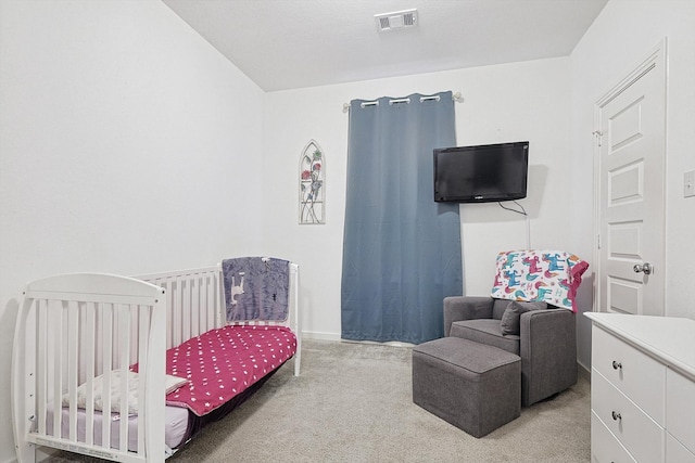 carpeted bedroom with a nursery area