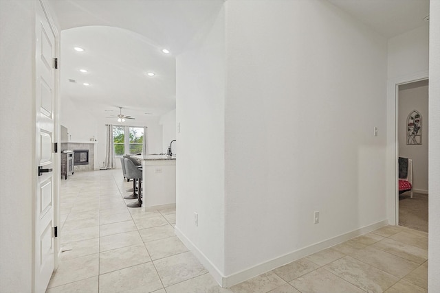 hall with light tile patterned floors and sink