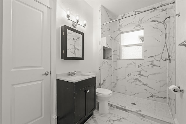 bathroom with toilet, vanity, and tiled shower