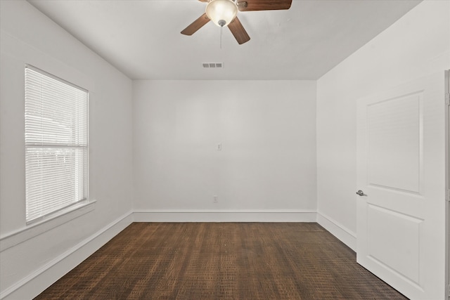 empty room with ceiling fan and dark colored carpet