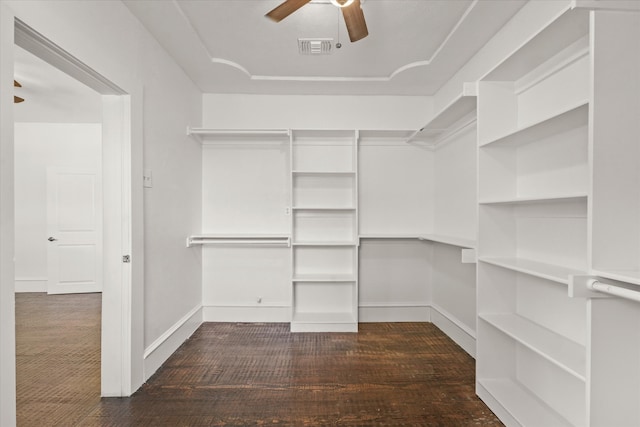 spacious closet with dark carpet and ceiling fan