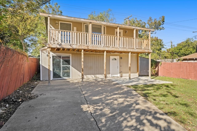 back of house with a yard, a balcony, and a patio