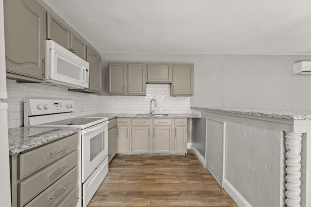 kitchen with light stone countertops, dark hardwood / wood-style flooring, gray cabinetry, white appliances, and sink