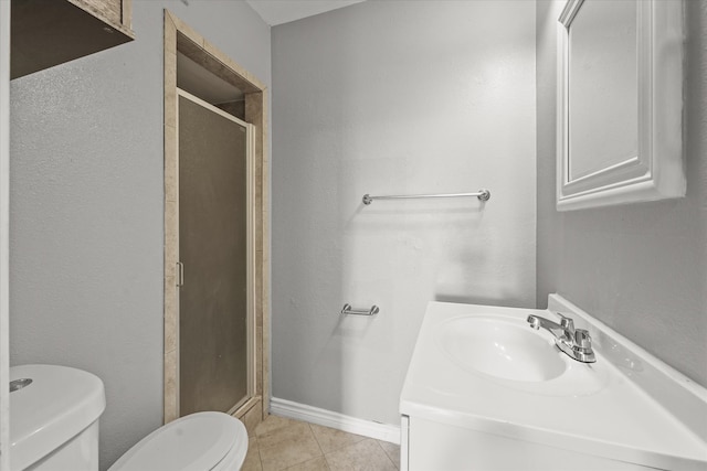 bathroom featuring tile patterned flooring, vanity, toilet, and walk in shower