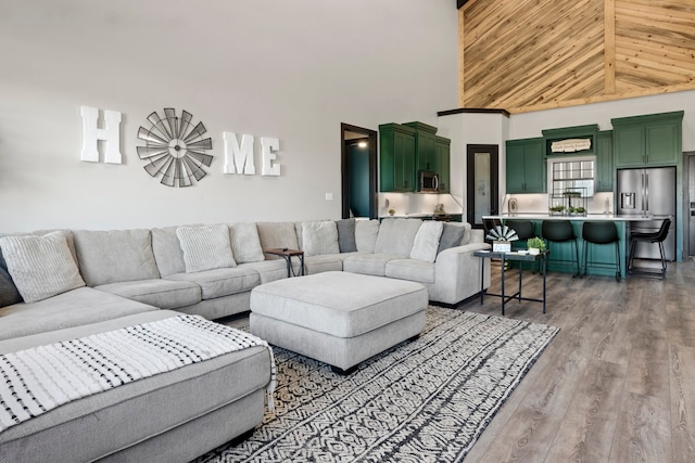 living room with hardwood / wood-style floors and high vaulted ceiling