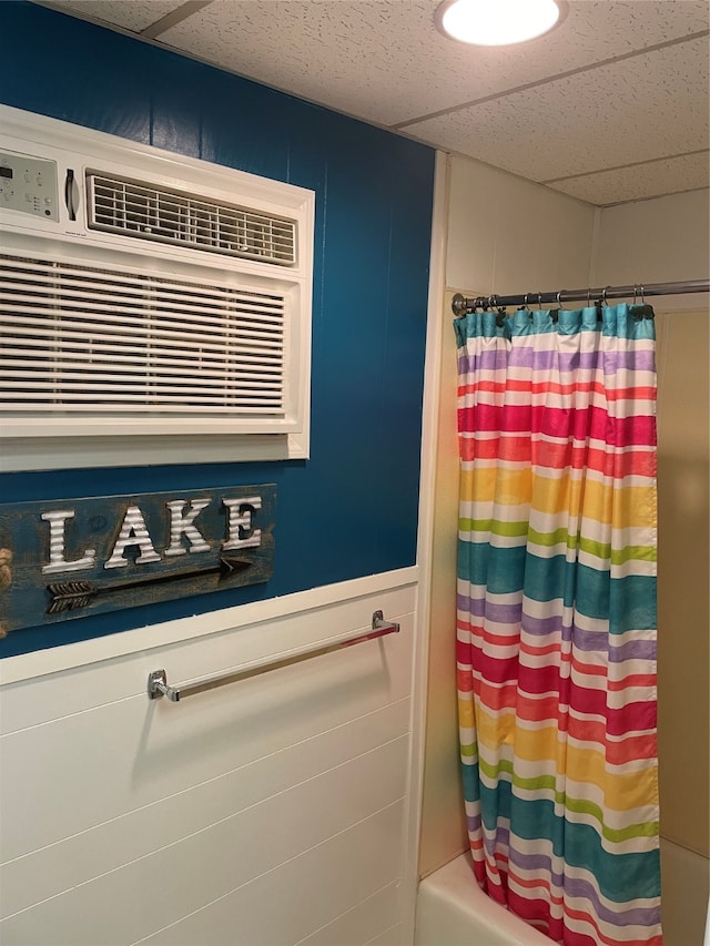 bathroom featuring a drop ceiling and shower / bath combination with curtain