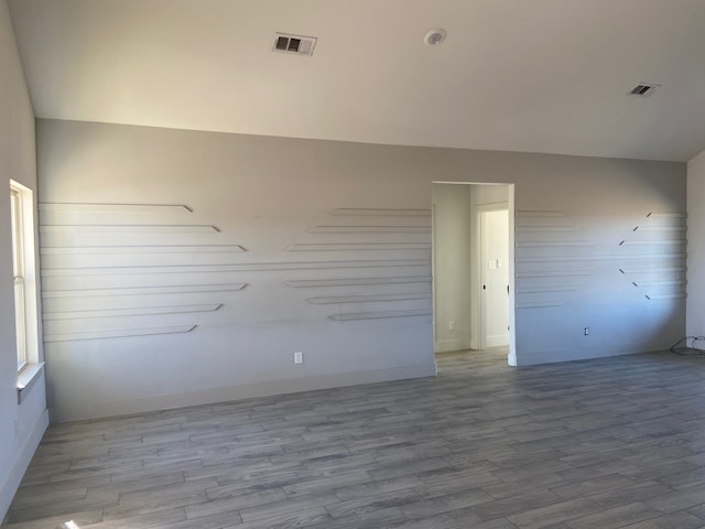 unfurnished room with lofted ceiling and light hardwood / wood-style flooring