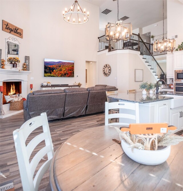 dining space with a high ceiling, dark wood-type flooring, and sink