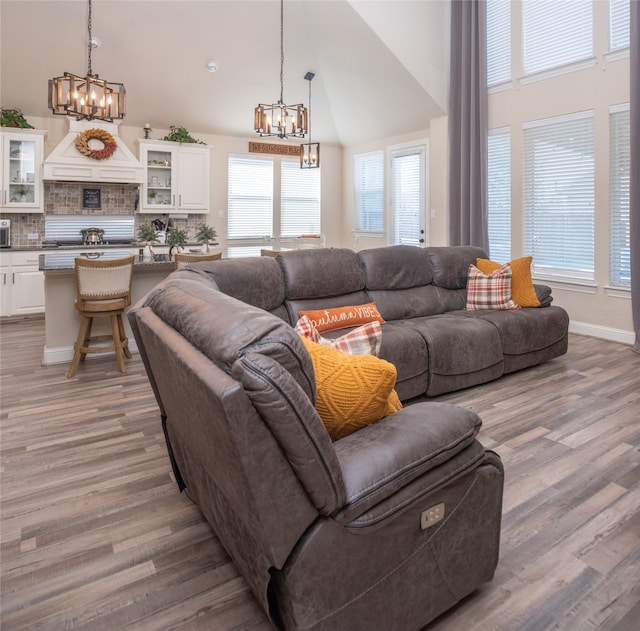 living room with light wood-type flooring and high vaulted ceiling