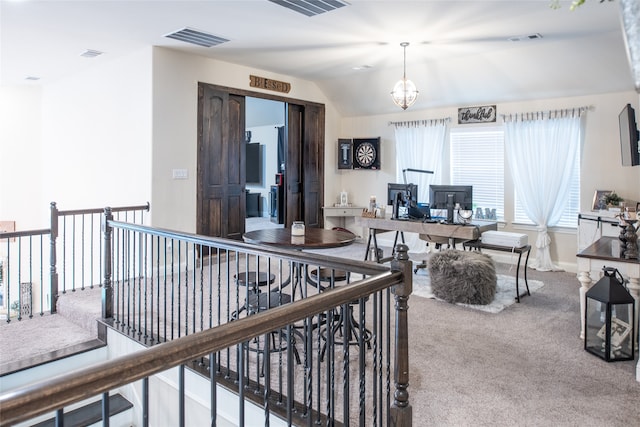 interior space with carpet floors, lofted ceiling, and a notable chandelier