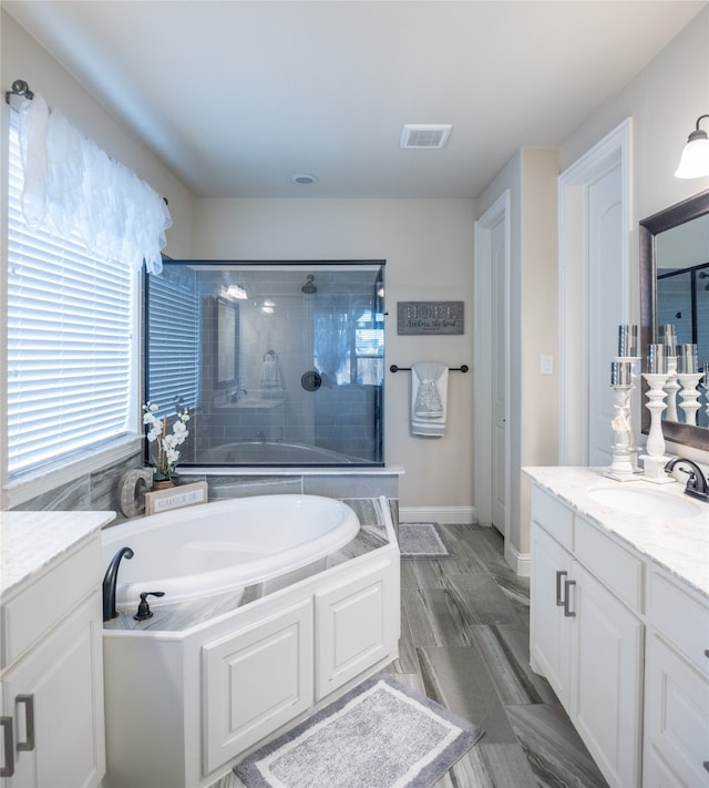 bathroom with plus walk in shower, vanity, and hardwood / wood-style flooring