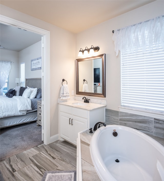 bathroom with vanity and a relaxing tiled tub