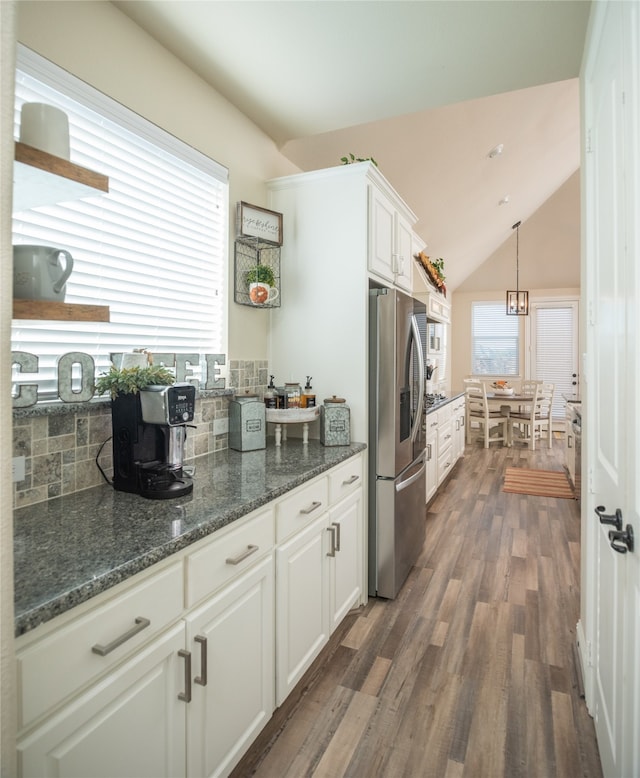 kitchen with white cabinets, vaulted ceiling, tasteful backsplash, dark hardwood / wood-style flooring, and stainless steel fridge with ice dispenser