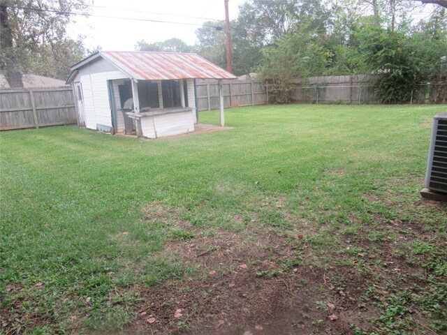 view of yard featuring a storage unit and central air condition unit