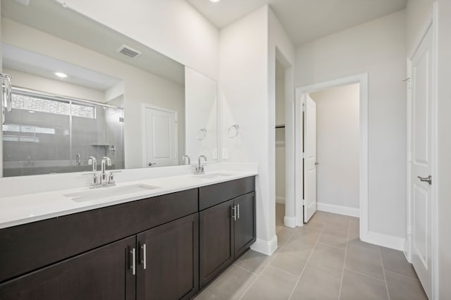 bathroom featuring tile patterned flooring, vanity, and a shower with shower door