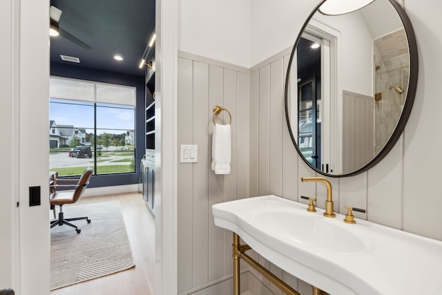 bathroom with wood-type flooring, ceiling fan, and sink