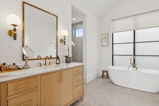 bathroom featuring vanity, a bath, and lofted ceiling