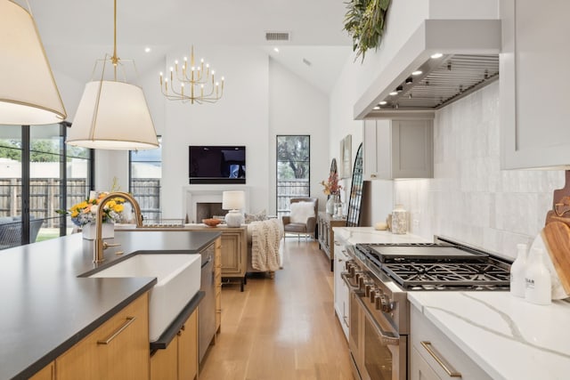 kitchen with white cabinets, decorative backsplash, range with two ovens, and custom range hood