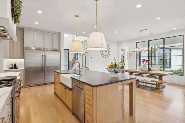 kitchen featuring custom exhaust hood, a kitchen island with sink, high quality appliances, and sink