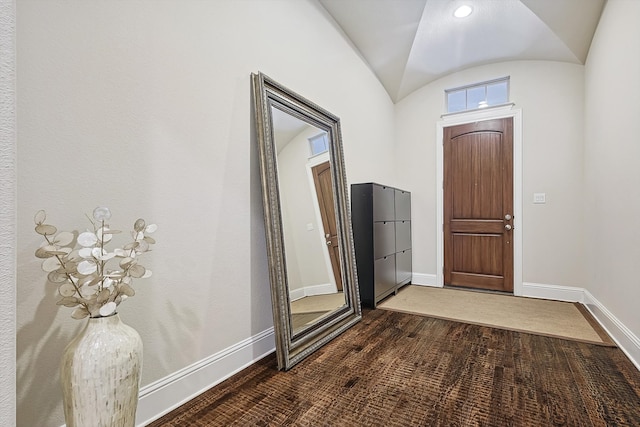 entrance foyer with vaulted ceiling and dark hardwood / wood-style floors