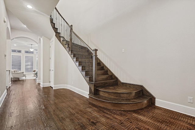 stairs with wood-type flooring and ceiling fan