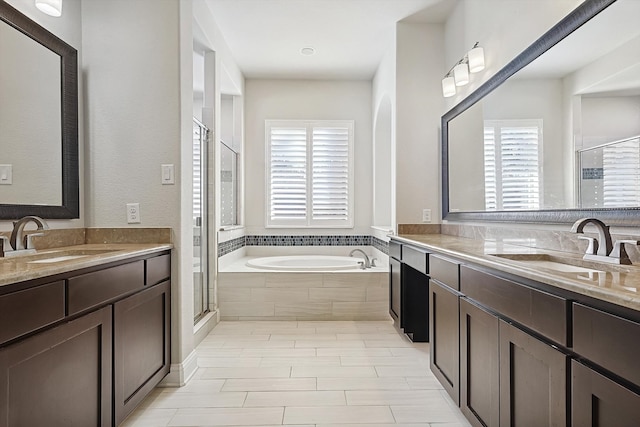 bathroom featuring shower with separate bathtub, plenty of natural light, and vanity