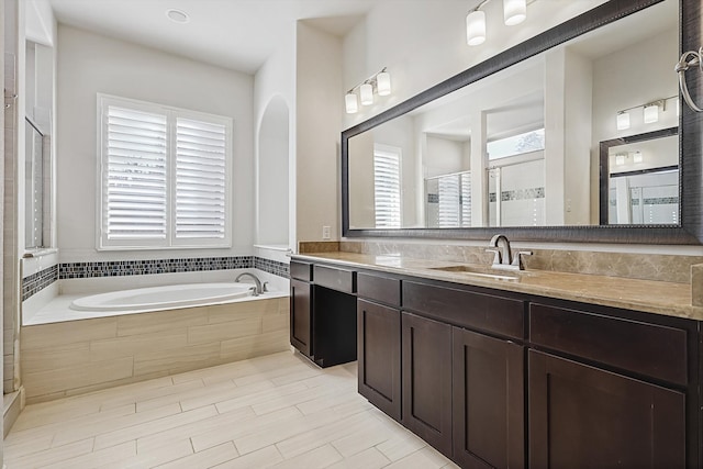 bathroom with independent shower and bath and vanity