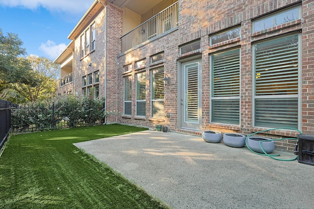 doorway to property featuring a patio area and a lawn