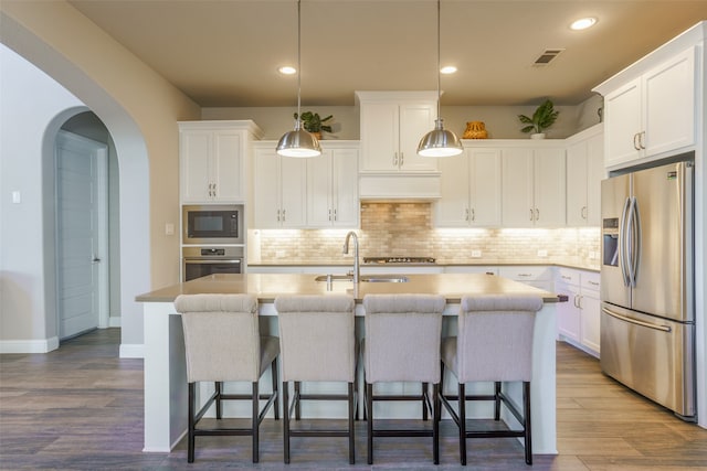 kitchen with white cabinets, an island with sink, and appliances with stainless steel finishes