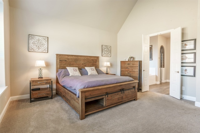 bedroom featuring light colored carpet and high vaulted ceiling