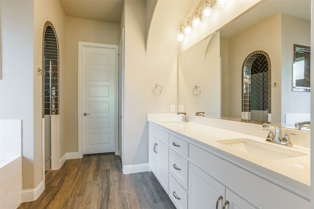 bathroom featuring hardwood / wood-style floors, vanity, and shower with separate bathtub