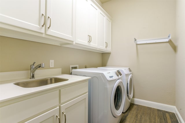 clothes washing area with dark hardwood / wood-style flooring, sink, cabinets, and independent washer and dryer