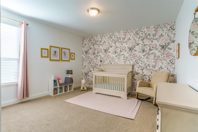 bedroom featuring multiple windows, carpet, and a crib