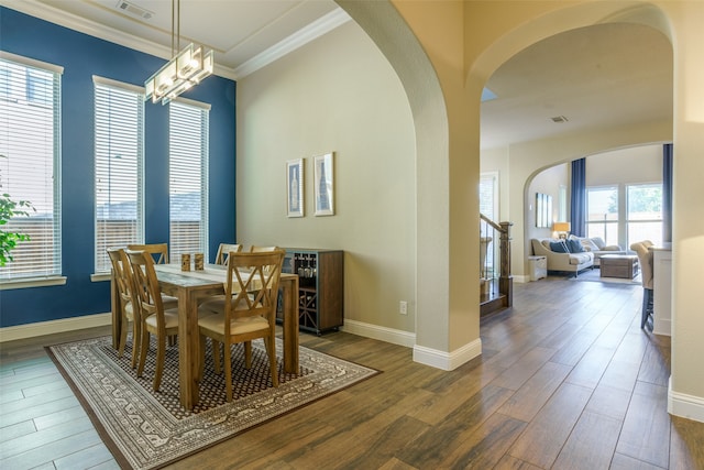 dining room featuring plenty of natural light, an inviting chandelier, dark hardwood / wood-style floors, and ornamental molding