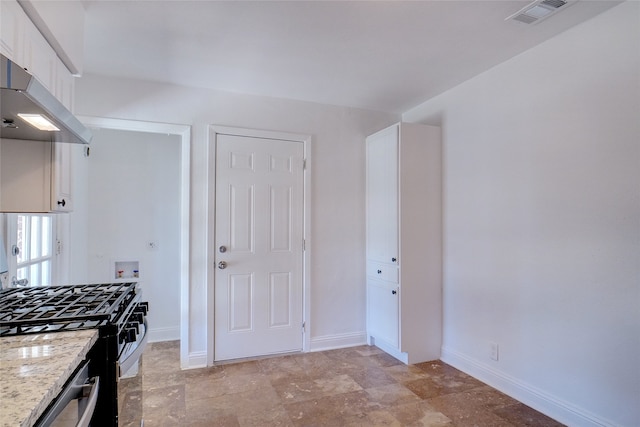 kitchen featuring white cabinetry, light stone countertops, stainless steel appliances, and extractor fan