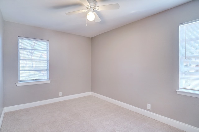 carpeted spare room featuring ceiling fan