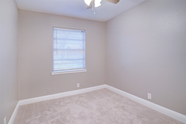 spare room with ceiling fan and light colored carpet