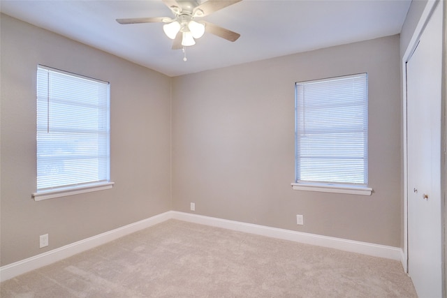 carpeted empty room featuring plenty of natural light and ceiling fan