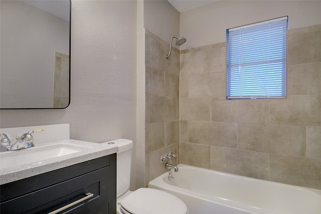 full bathroom with vanity, tiled shower / bath, and toilet