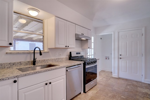 kitchen with light stone countertops, sink, white cabinetry, and stainless steel appliances