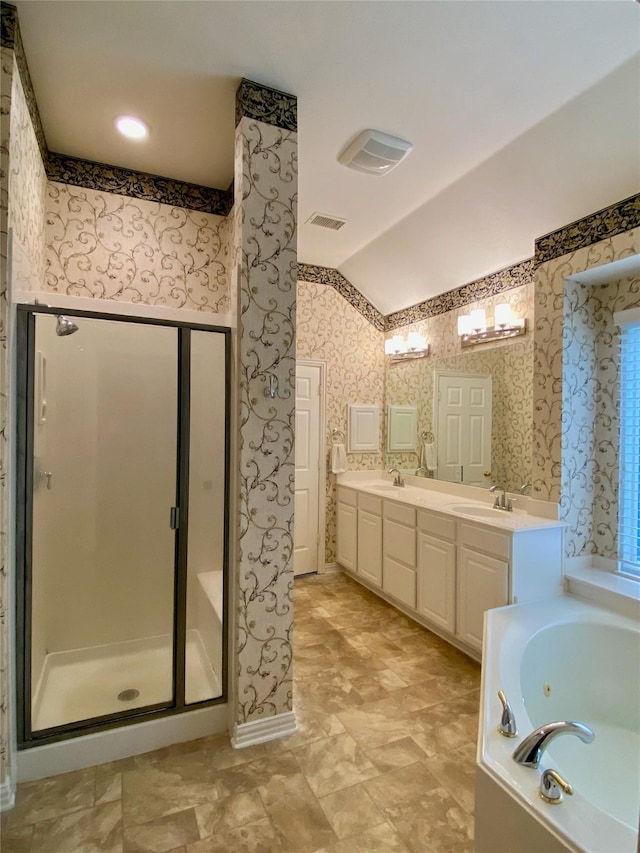 bathroom featuring vanity, independent shower and bath, and lofted ceiling